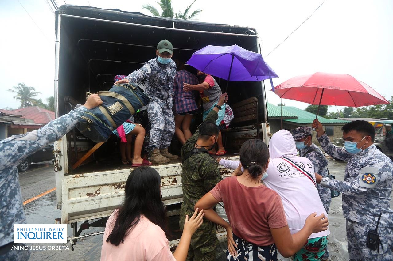 (FILE) Philippine Coast Guard, Philippine National Police and Philippine Air Force assist residents as they leave their homes in Barangay Buso-Buso in Laurel town in Batangas following forced evacuation on Sunday, July 3, 2021.  (Photo courtesy of Niño Jesus Orbeta/Philippine Daily Inquirer)